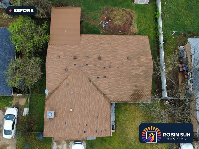 Drone view straight down on a worn tan shingle roof before replacement.