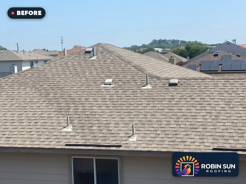 Low drone view across a faded beige shingle roof before replacement.